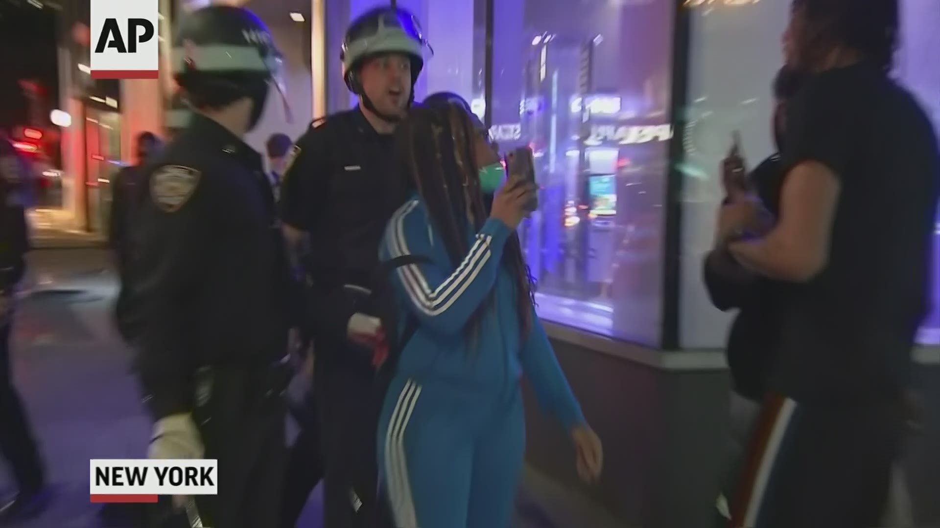 A video shows more than a half dozen officers confronting the journalists as they filmed police ordering protesters to go home shortly after curfew. (Via AP)