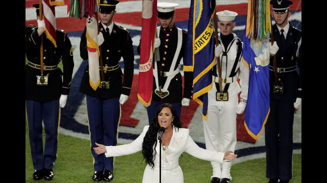 Military personnel carry the colors before the start of an NFL