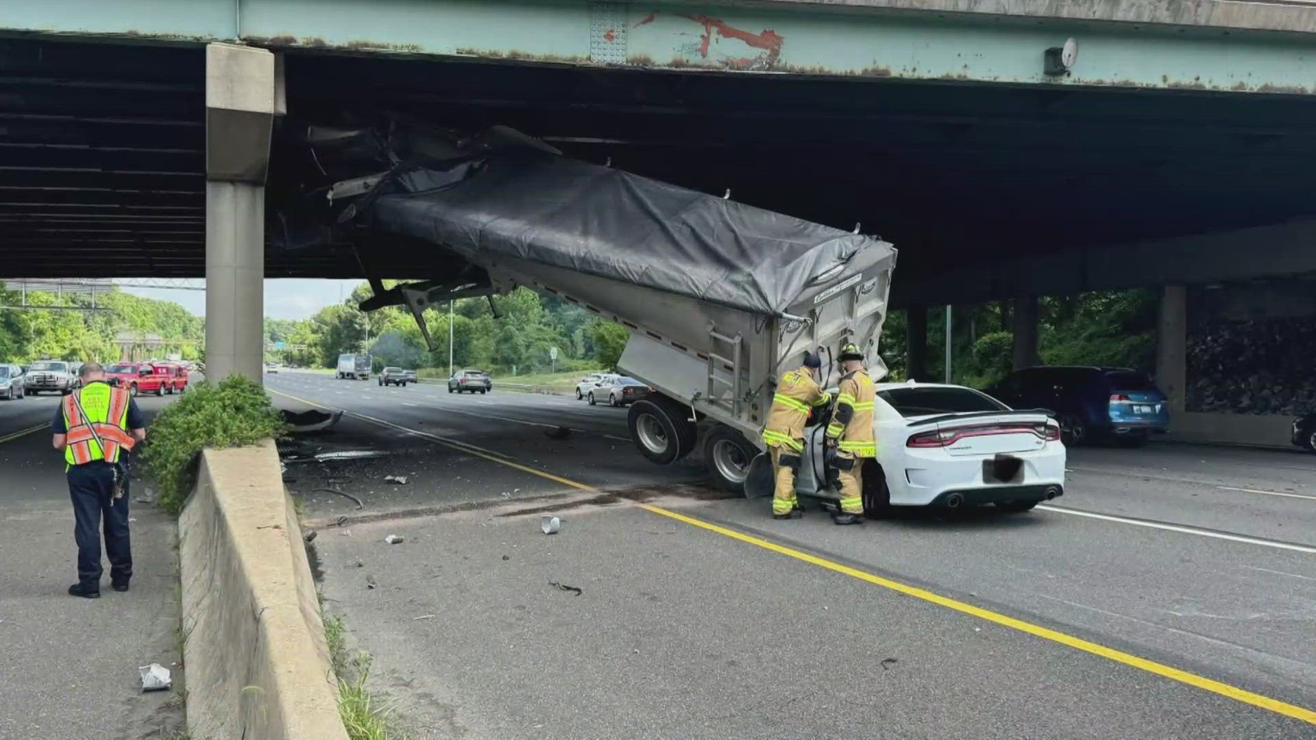 Authorities say a truck trailer struck a bridge and a car. There are no fatalities reported as of now. Some lanes are blocked.