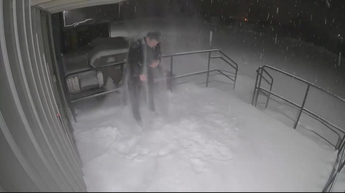 Wisconsin police officer covered in snow as he shuts door behind him