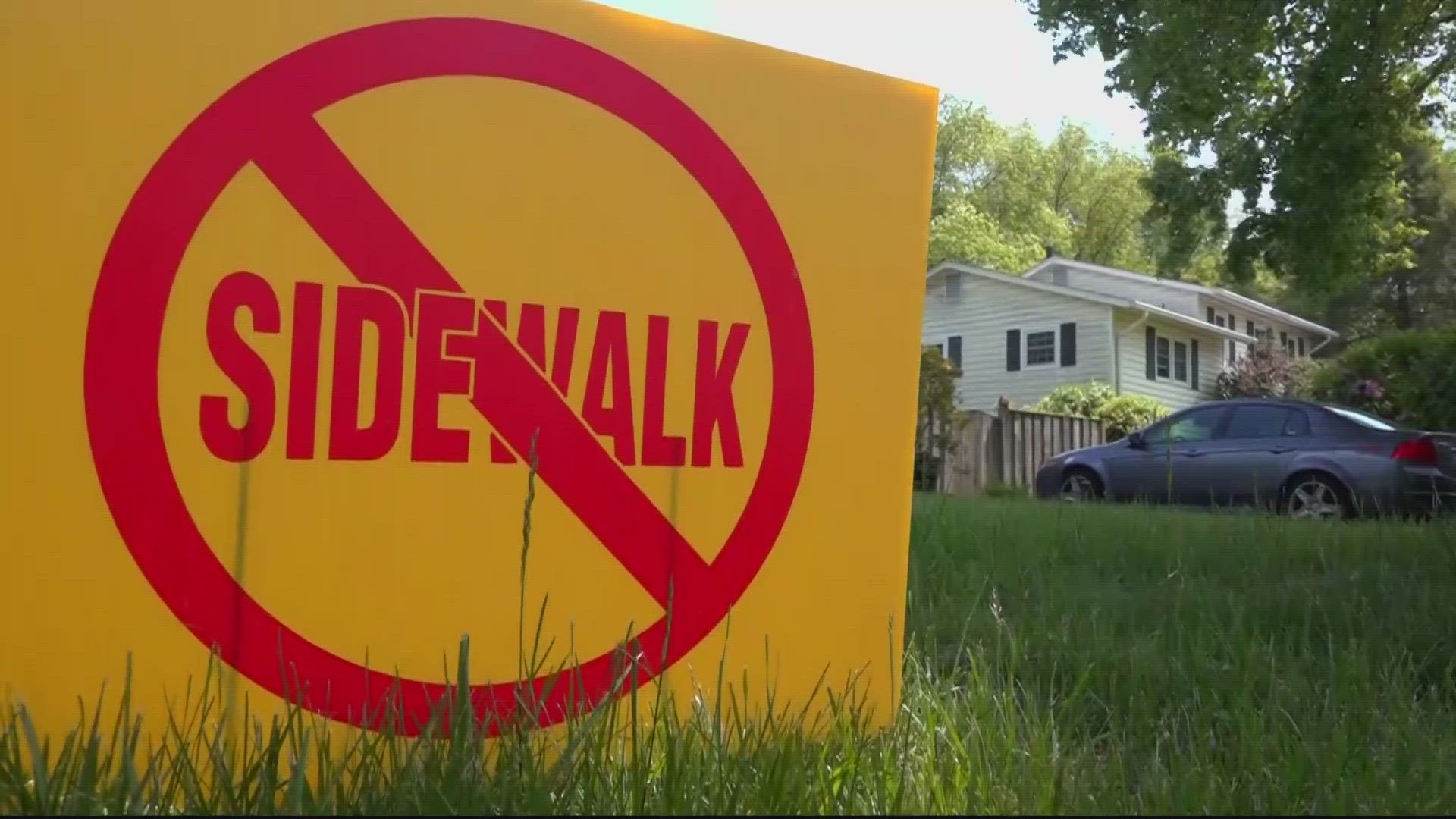 Opponents of sidewalk in Rock Creek Manor celebrate tree preservation as supporters worry about children walking to school.