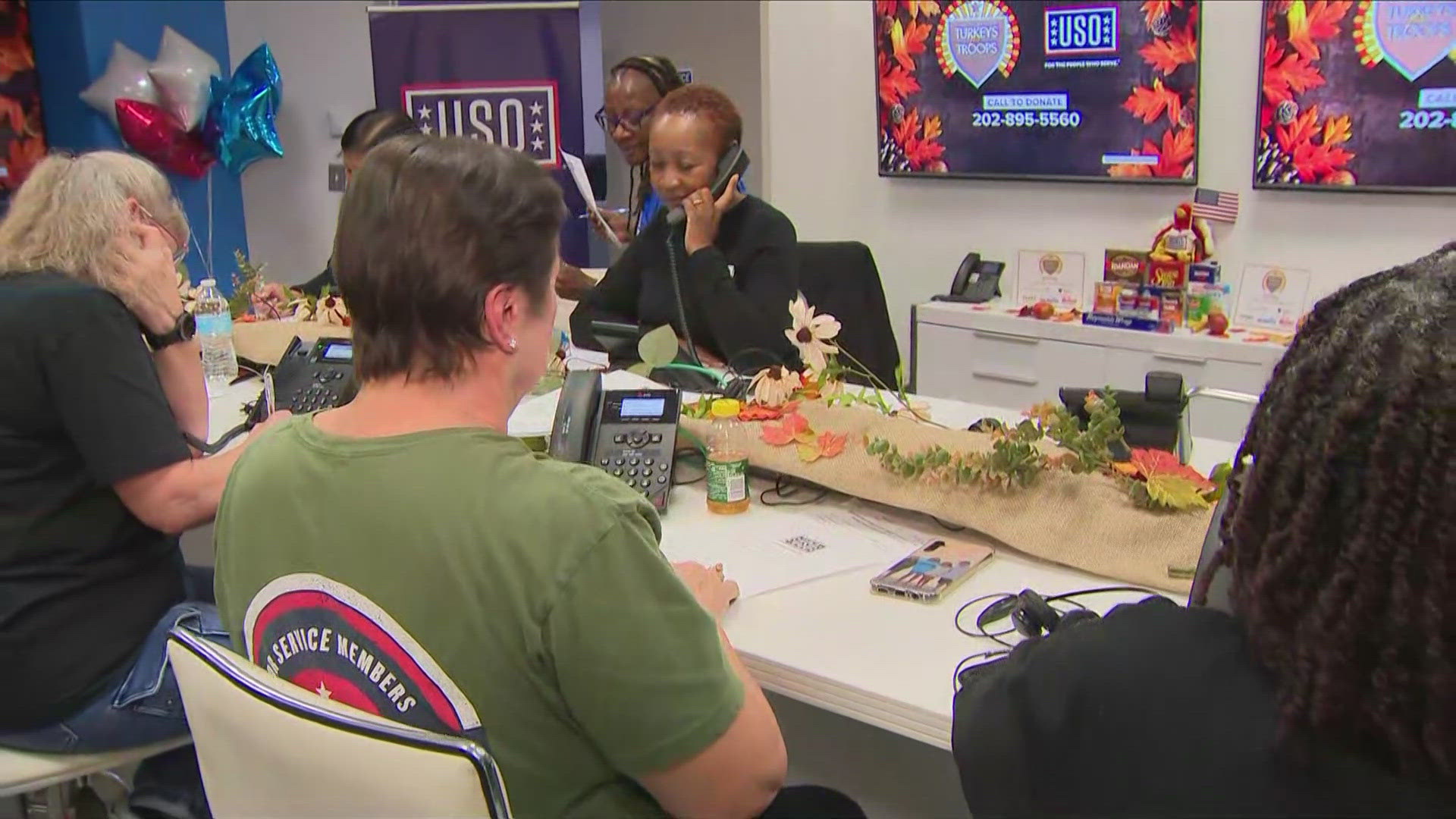 Volunteers with USO help pack up boxes filled with Thanksgiving meal staples and then help distribute them to local military families.