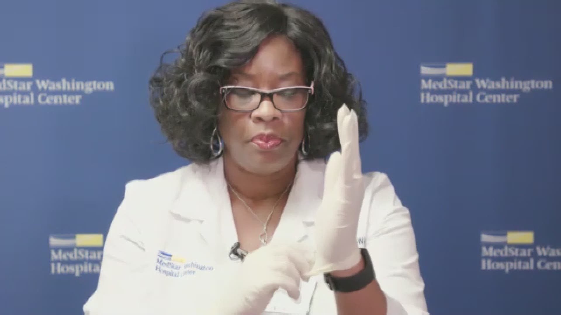 MedStar Washintgon Hospital Center's director of infection control and prevention Pam Farrare-Wilmore demonstrates how to properly take off disposable gloves.