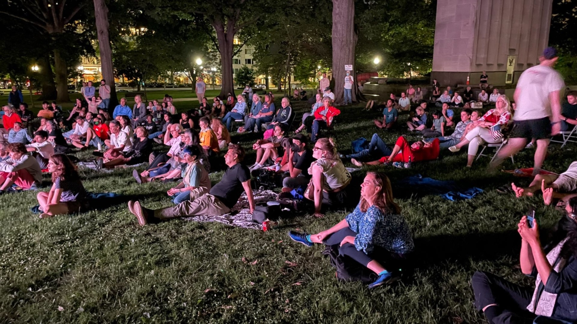 More than 100 people gathered a block away from the Capitol Building to view the first night of the hearing on an outdoor projection screen.