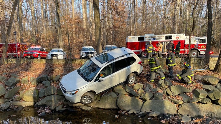 2 taken to hospital after car found hanging above creek on pile of rocks