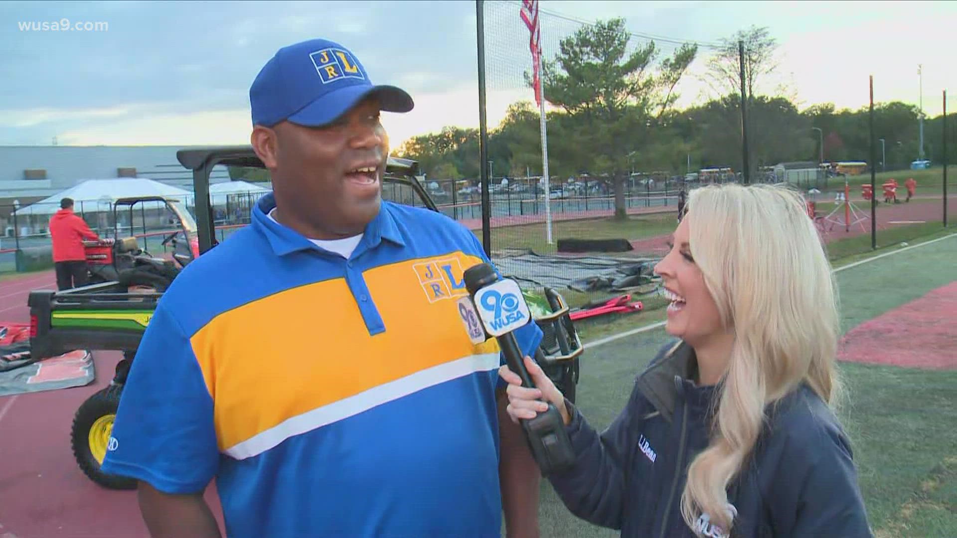 John Lewis head football coach Larry Choates talks with Sharla pre-game about facing a team during their homecoming game.