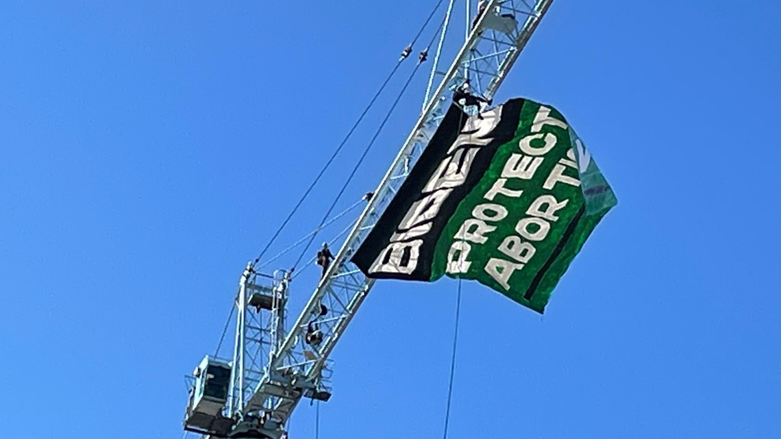 Watch live: Pair of Women's March activists climb crane to reveal banner in DC