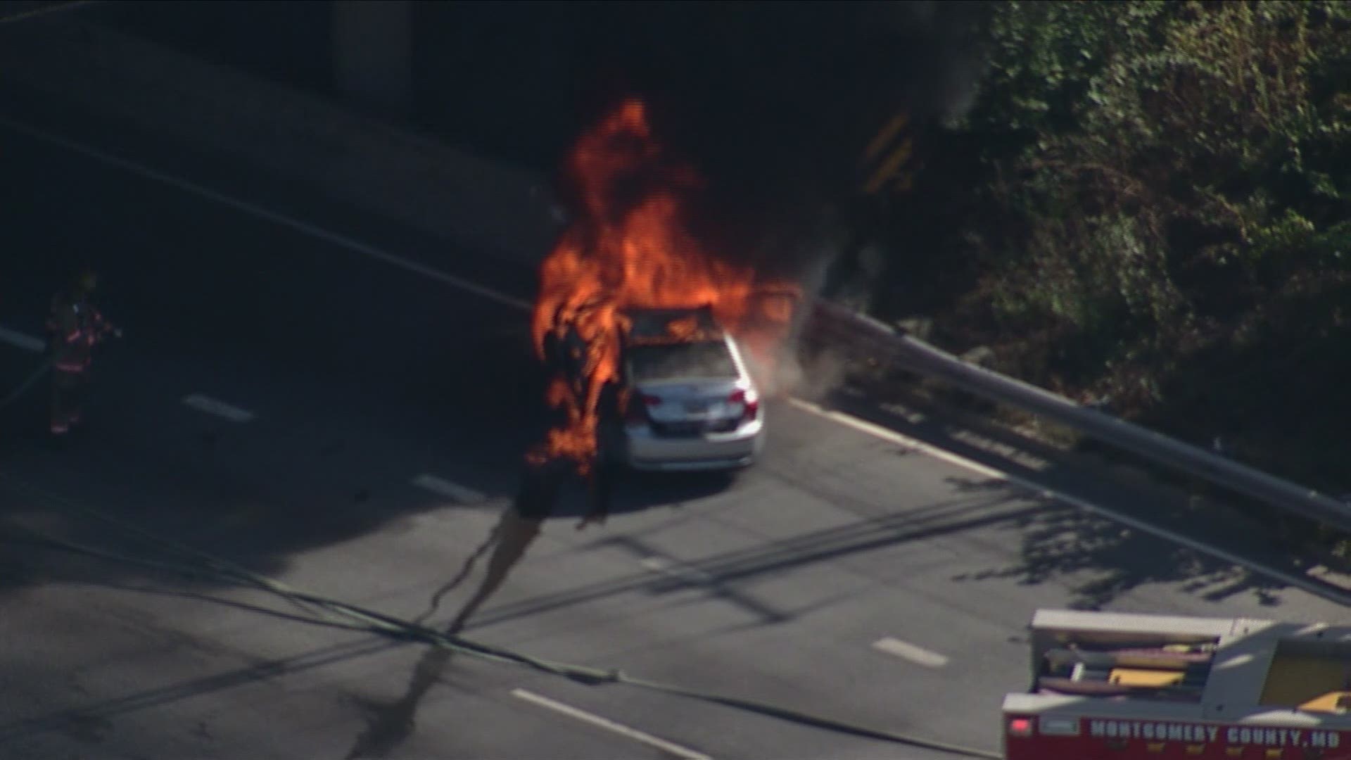 A car is engulfed in flames along Interstate 495 at Colesville Road in Silver Spring, Maryland.